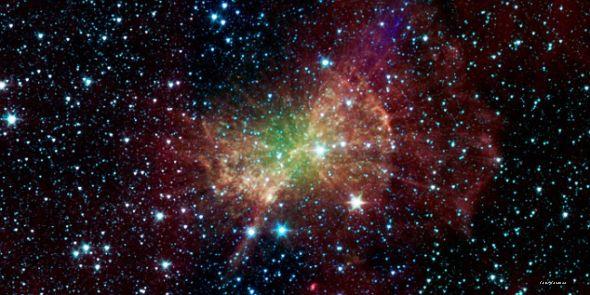 美国宇航局斯皮策太空望远镜拍摄的这张图片，显示的是哑铃星云发射出大量红外辐射。这个“行星状星云”被它中心的死亡恒星的内核照亮1360光年外哑铃星云残骸展现太阳死亡后景象哑铃星云